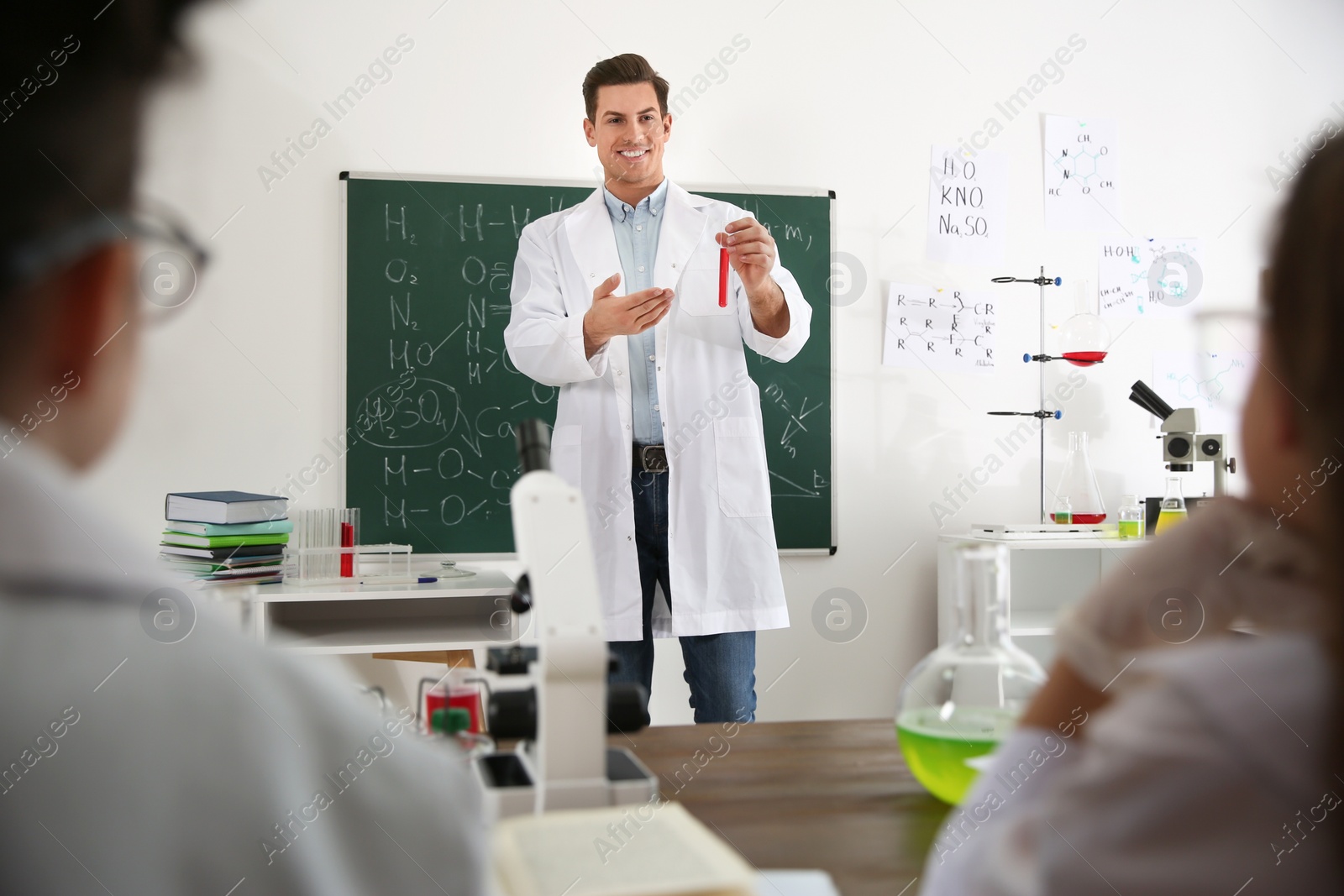 Photo of Teacher with pupils at chemistry lesson in classroom