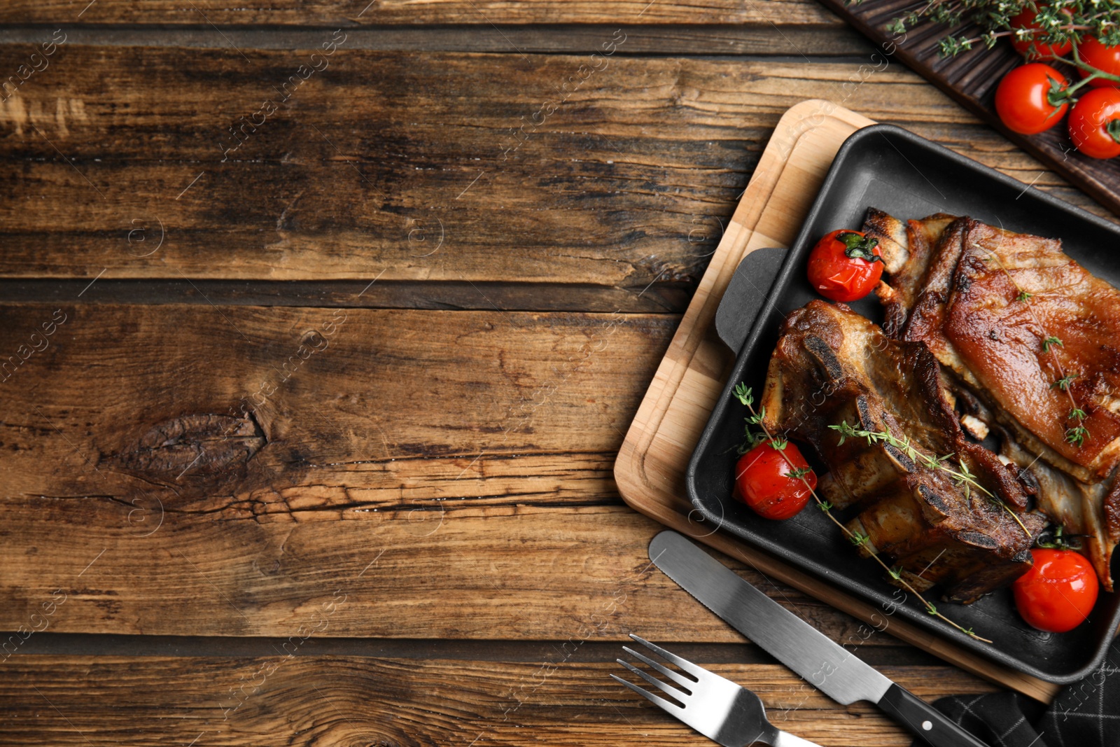 Photo of Delicious roasted ribs served on wooden table, flat lay. Space for text