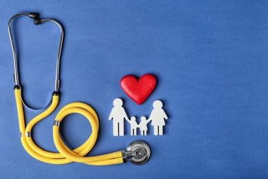 Photo of Flat lay composition with heart, stethoscope and family figure on color background, space for text. Life insurance concept