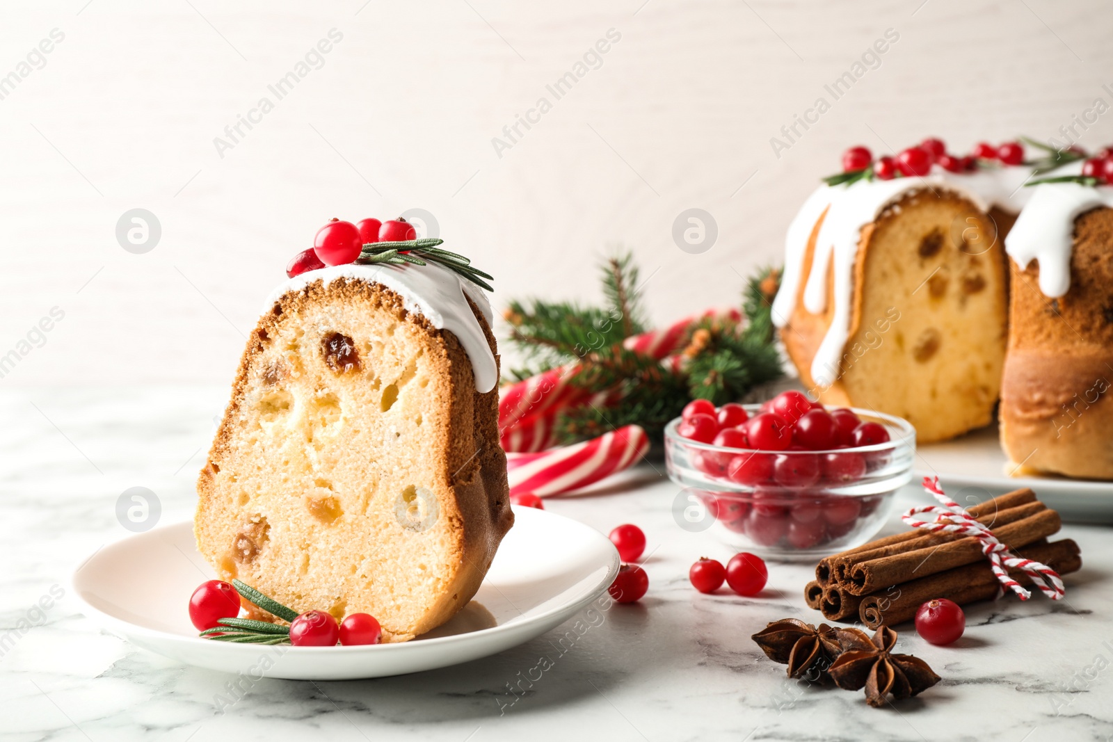 Photo of Composition with piece of traditional homemade Christmas cake on white marble table, closeup