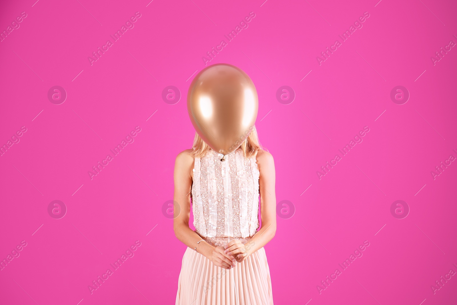 Photo of Young woman hiding behind air balloon on color background