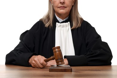 Photo of Judge with gavel at wooden table on white background, closeup
