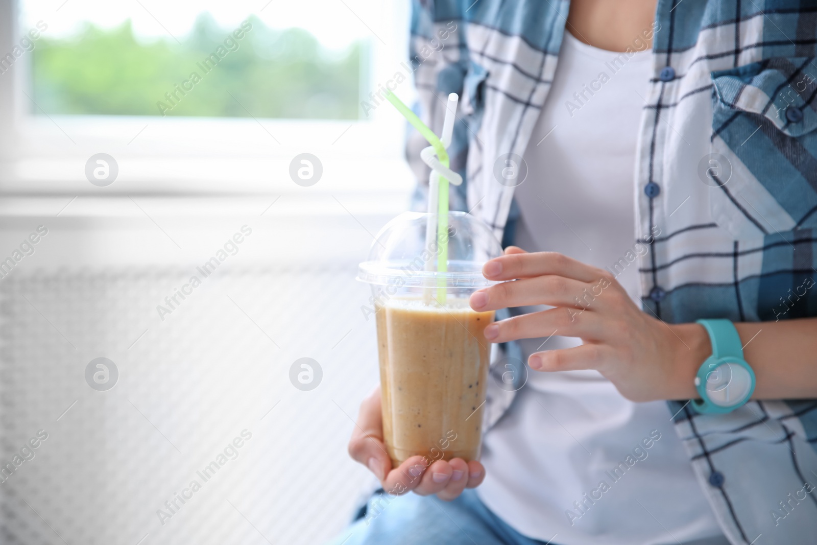 Photo of Young woman with plastic cup of healthy smoothie, closeup