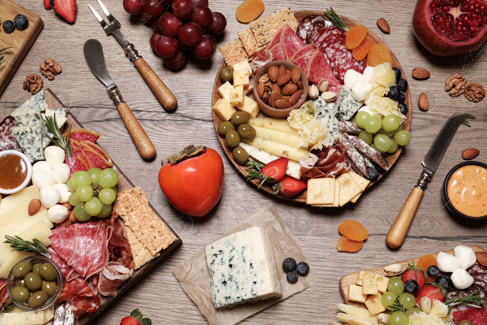 Photo of Assorted appetizers served on wooden table, flat lay