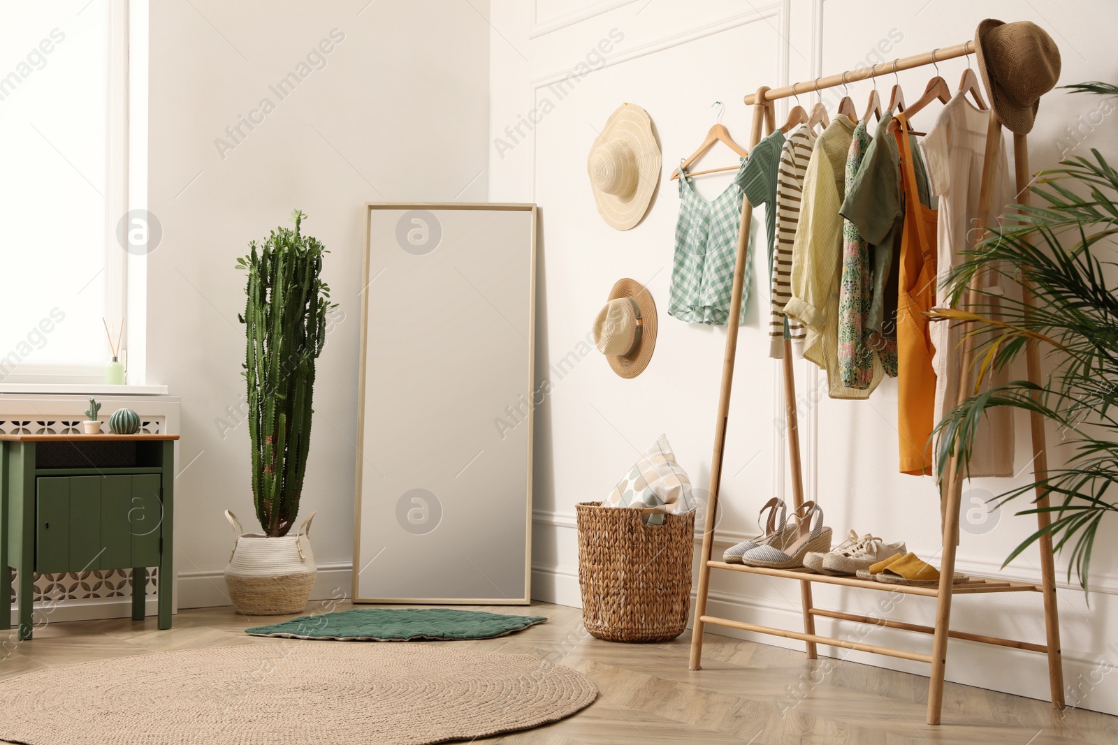 Photo of Modern room with clothes rack and big mirror. Interior design