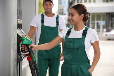 Photo of Workers in uniforms at modern gas station