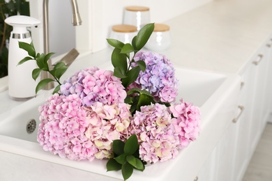 Photo of Bouquet with beautiful hydrangea flowers in sink