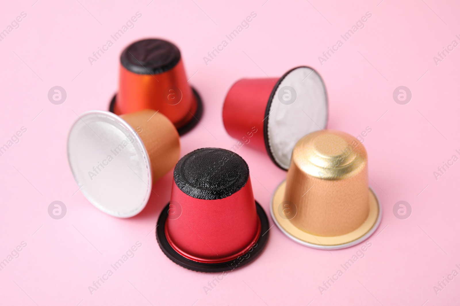 Photo of Many plastic coffee capsules on pink background, closeup