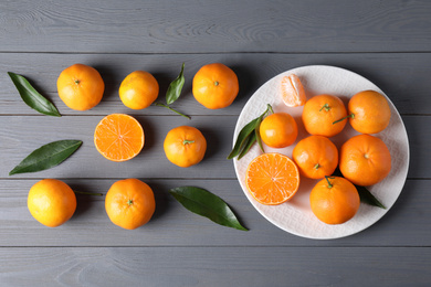 Fresh ripe tangerines on grey wooden table, flat lay