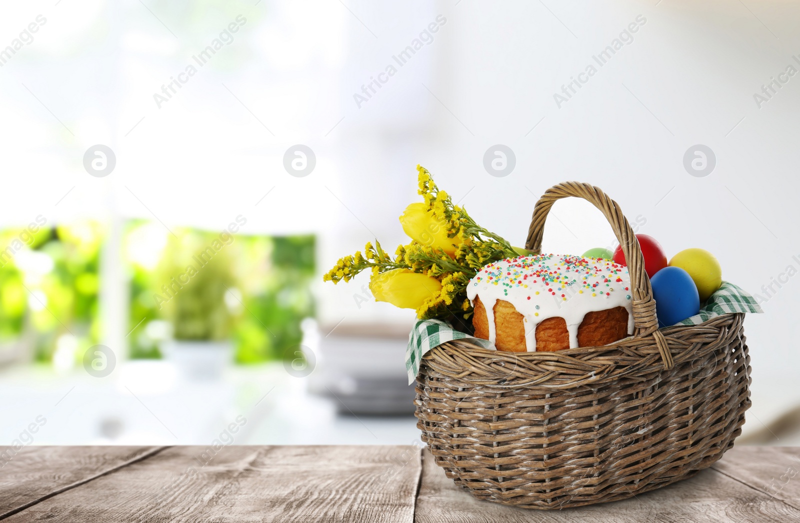 Image of Traditional Easter cake, dyed eggs and flowers in basket on wooden table. Space for text
