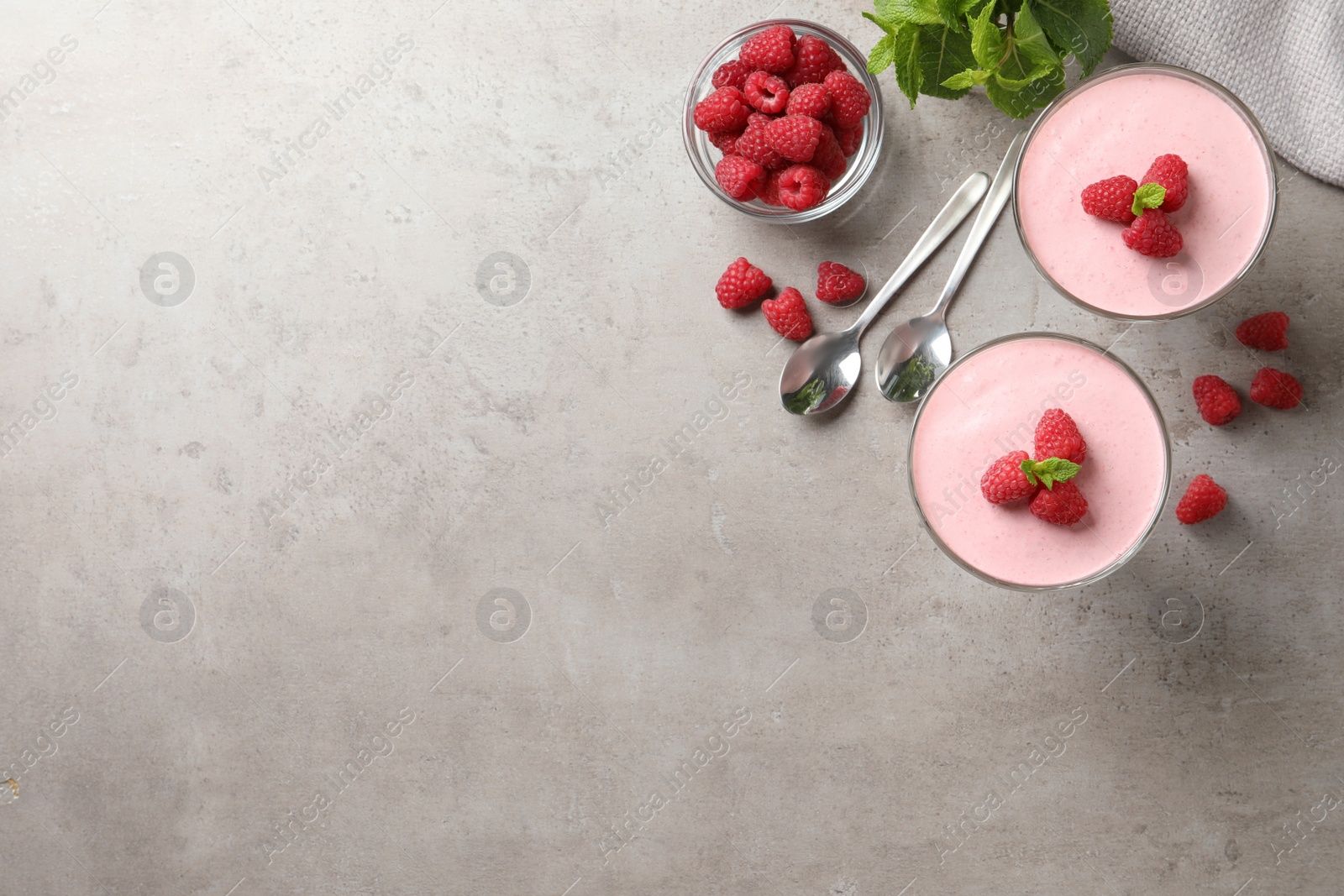 Photo of Delicious raspberry mousse with mint on light grey table, flat lay. Space for text