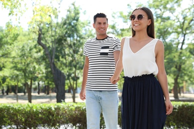 Photo of Lovely couple walking together in park on sunny day. Space for text