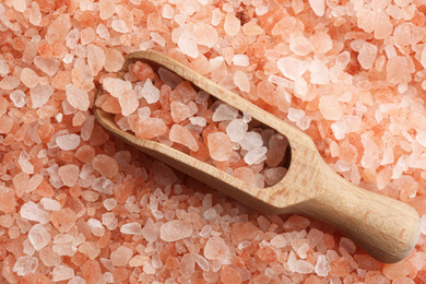 Photo of Pink himalayan salt and wooden scoop as background, top view