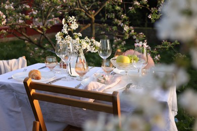 Photo of Stylish table setting with beautiful spring flowers in garden