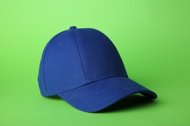 Photo of Stylish blue baseball cap on light green background