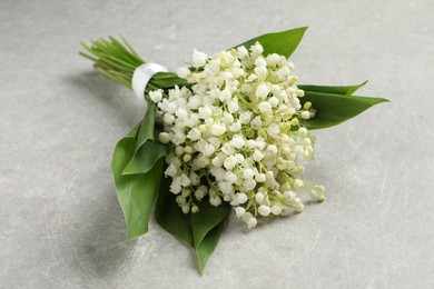 Photo of Beautiful lily of the valley bouquet on grey table