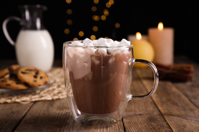 Photo of Glass cup of cocoa with marshmallows on wooden table