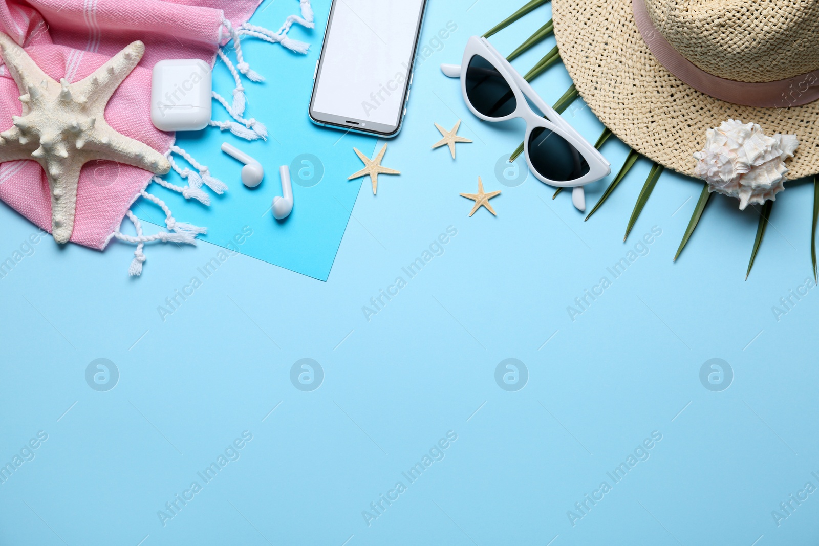 Photo of Flat lay composition with beach accessories on light blue background, space for text