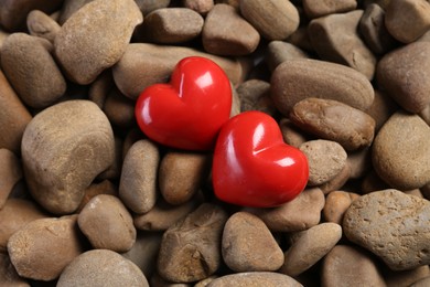 Photo of Red decorative hearts on stones, above view