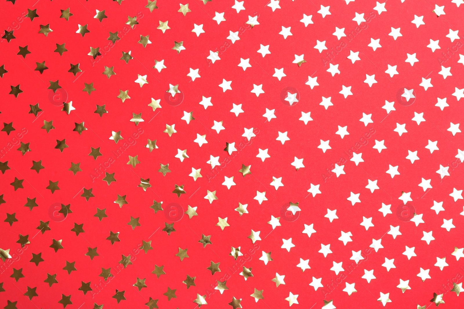 Photo of Confetti stars on red background, flat lay. Christmas celebration