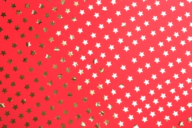 Photo of Confetti stars on red background, flat lay. Christmas celebration