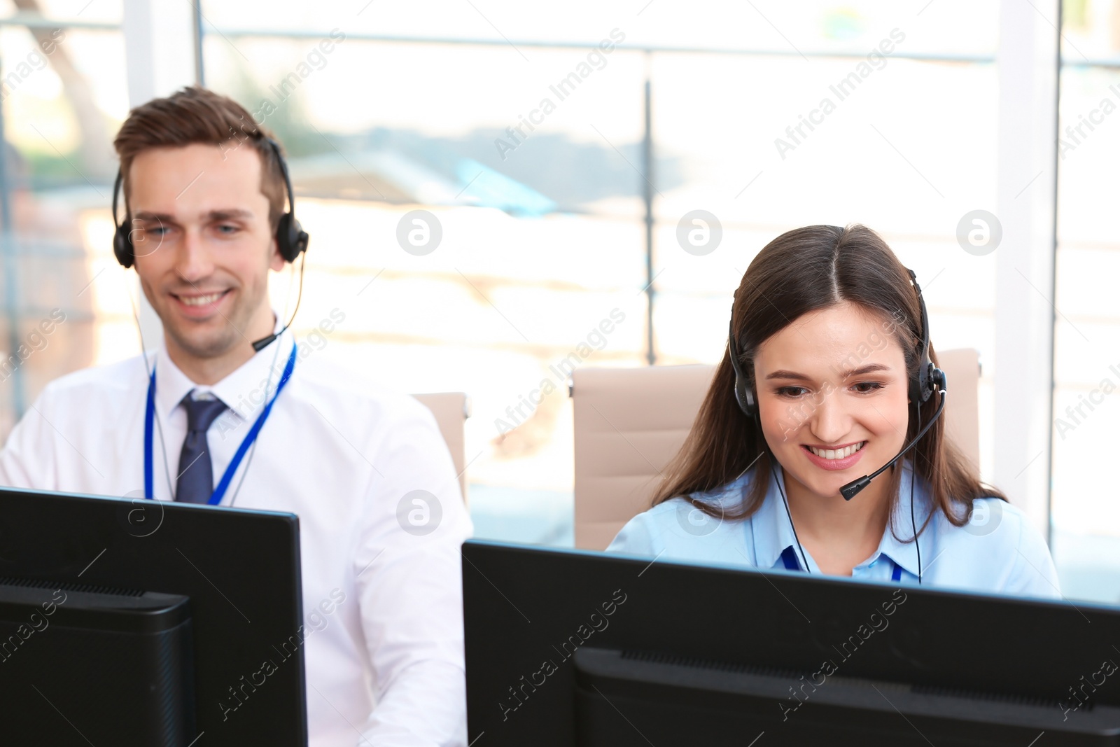 Photo of Technical support operators with headsets at workplace