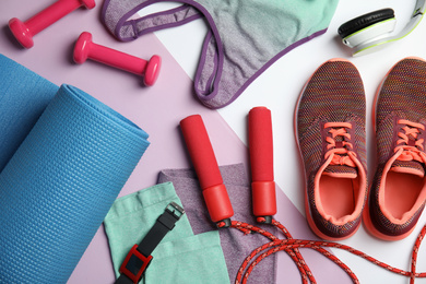 Photo of Flat lay composition with fitness equipment on color background