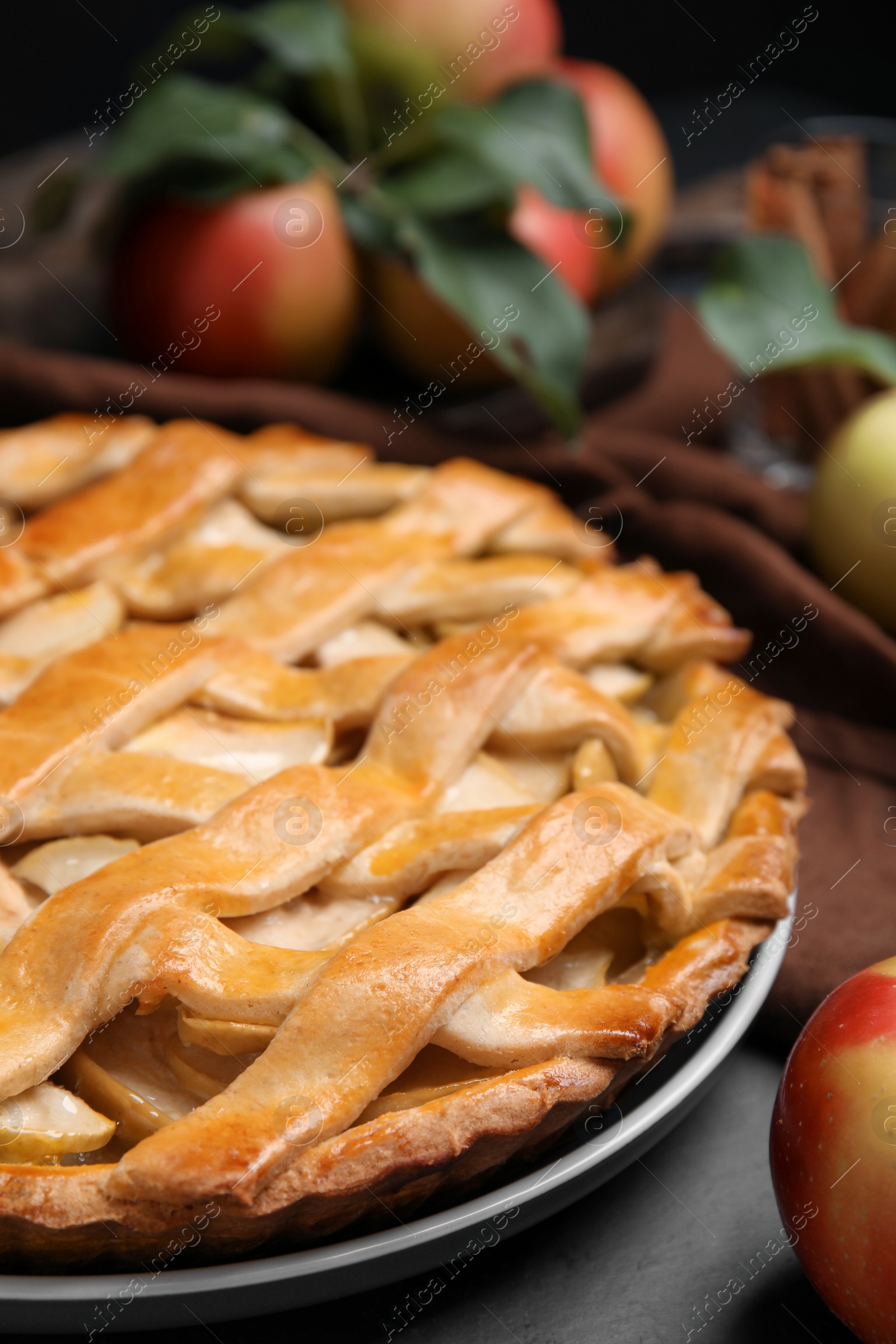 Photo of Delicious traditional apple pie on black table, closeup