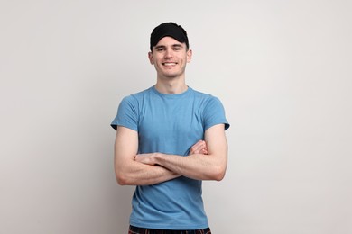 Photo of Happy man in pyjama and sleep mask on light grey background