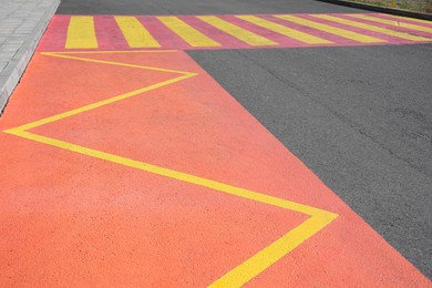Photo of Public transport stop sign in shape of zigzag painted on asphalt road