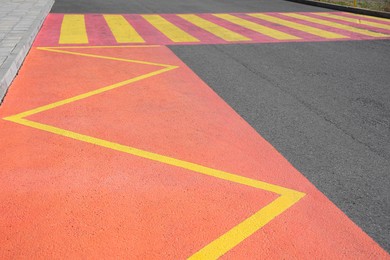 Public transport stop sign in shape of zigzag painted on asphalt road