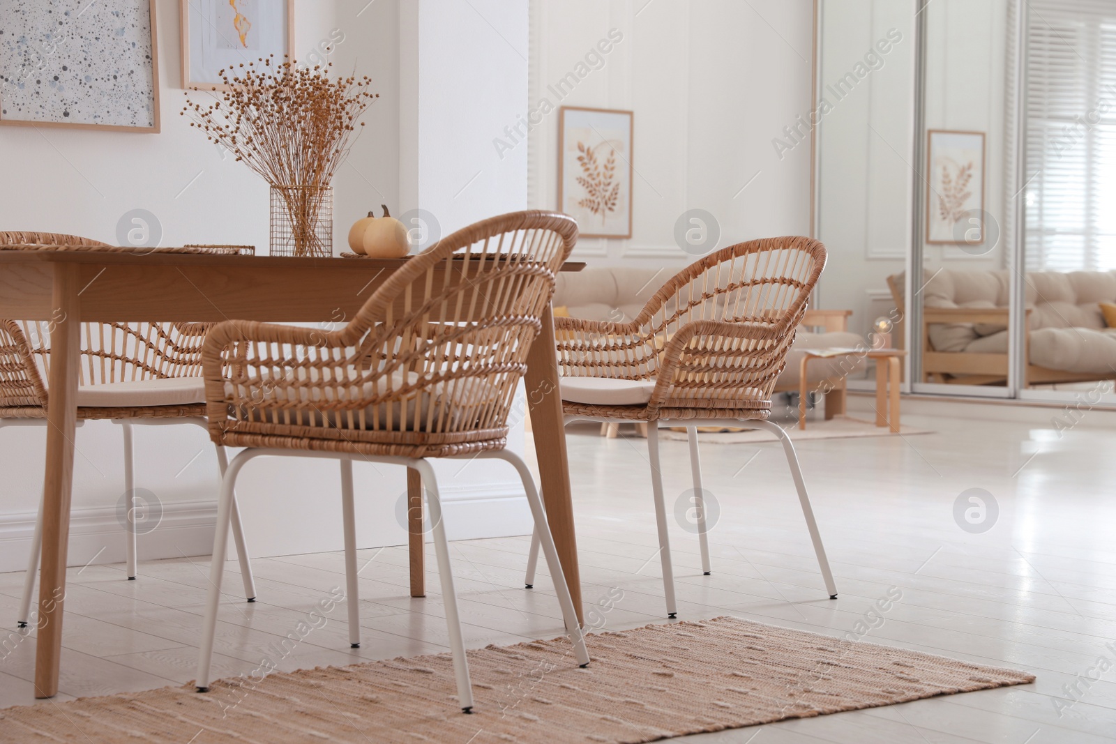 Photo of Dining room interior with wooden table and wicker chairs