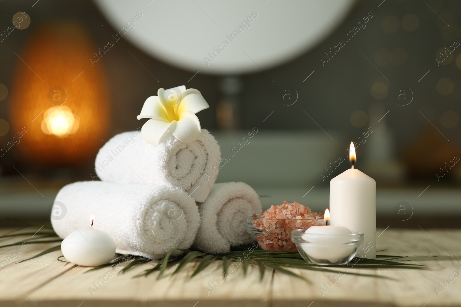 Photo of Composition with different spa products and burning candles on wooden table indoors