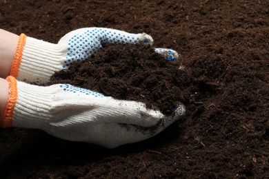 Photo of Woman holding fertile soil in hands, closeup. Gardening season