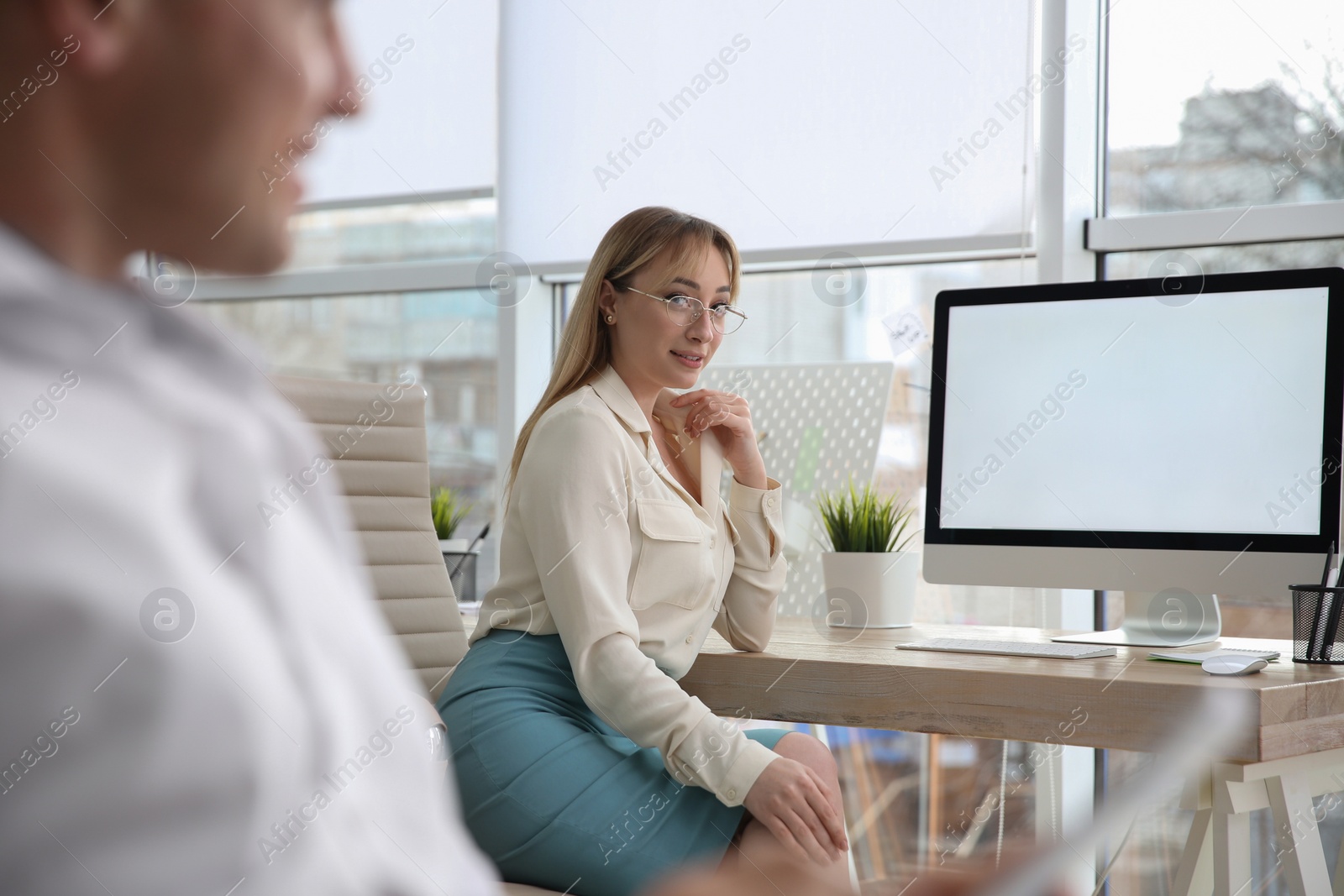 Photo of Young woman looking at her colleague in office. Flirting on job