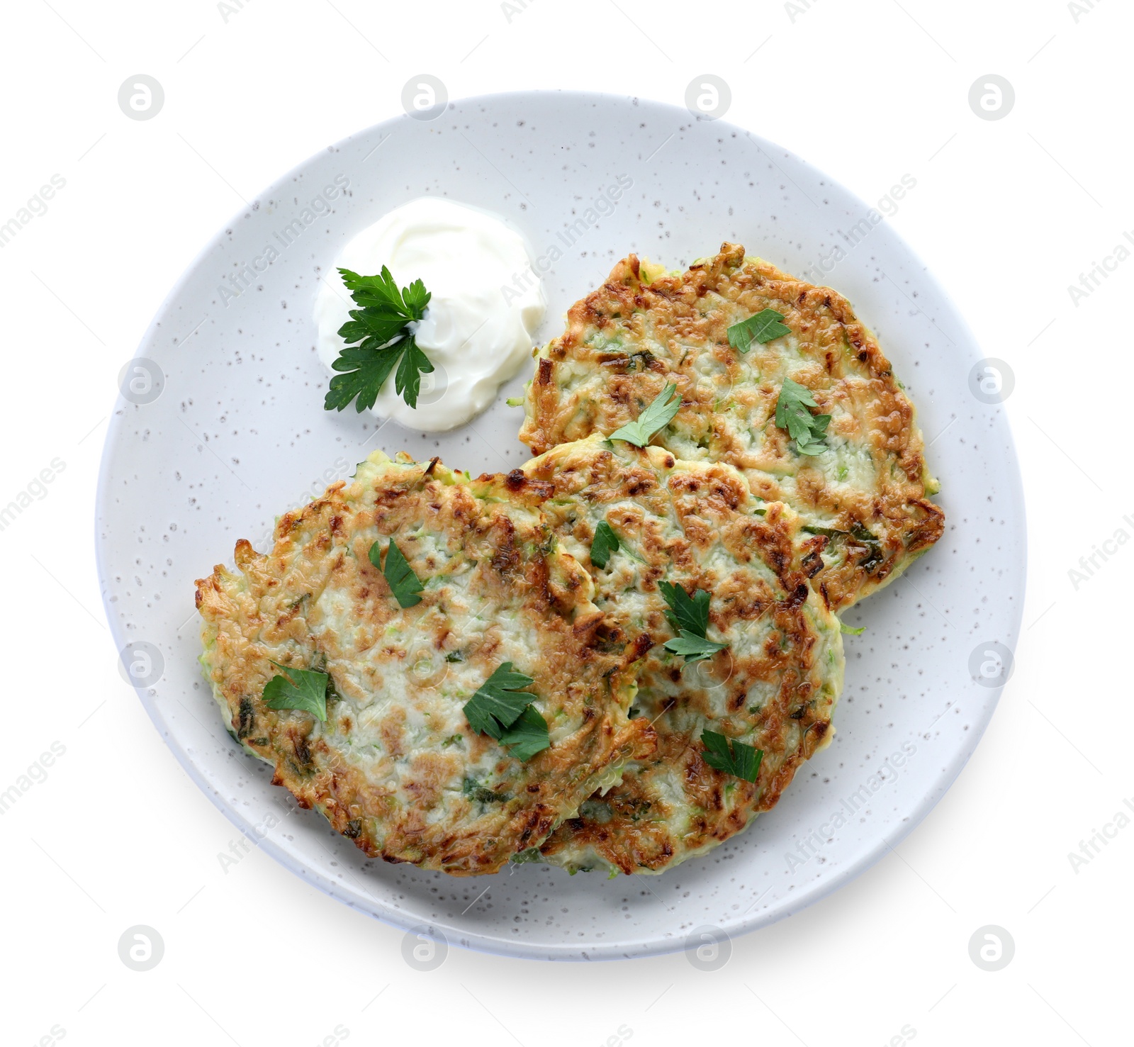 Photo of Delicious zucchini fritters with sour cream and parsley isolated on white, top view
