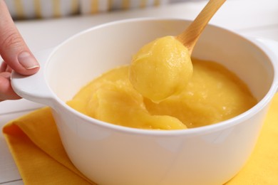 Woman cooking lemon curd at table, closeup