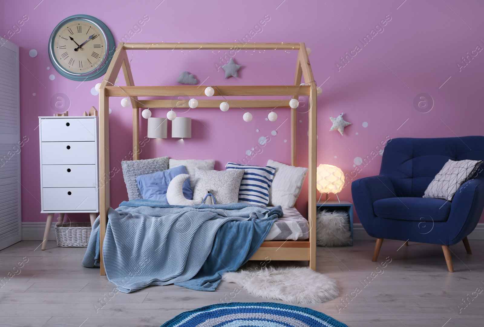 Photo of Child's room interior with comfortable bed and garland