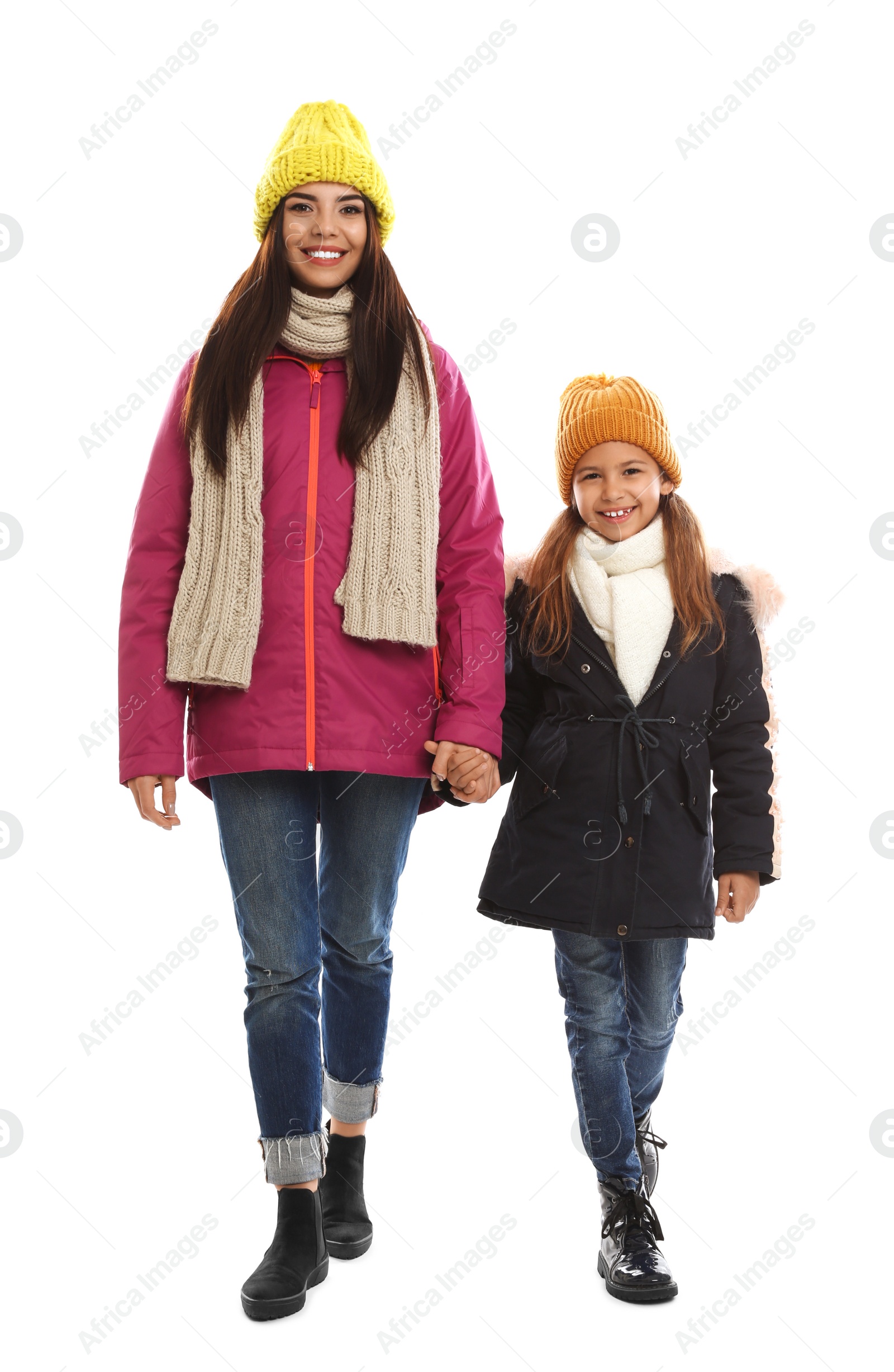 Photo of Happy mother and daughter in warm clothes on white background. Winter vacation