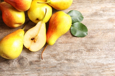 Photo of Ripe pears on wooden table, top view. Space for text