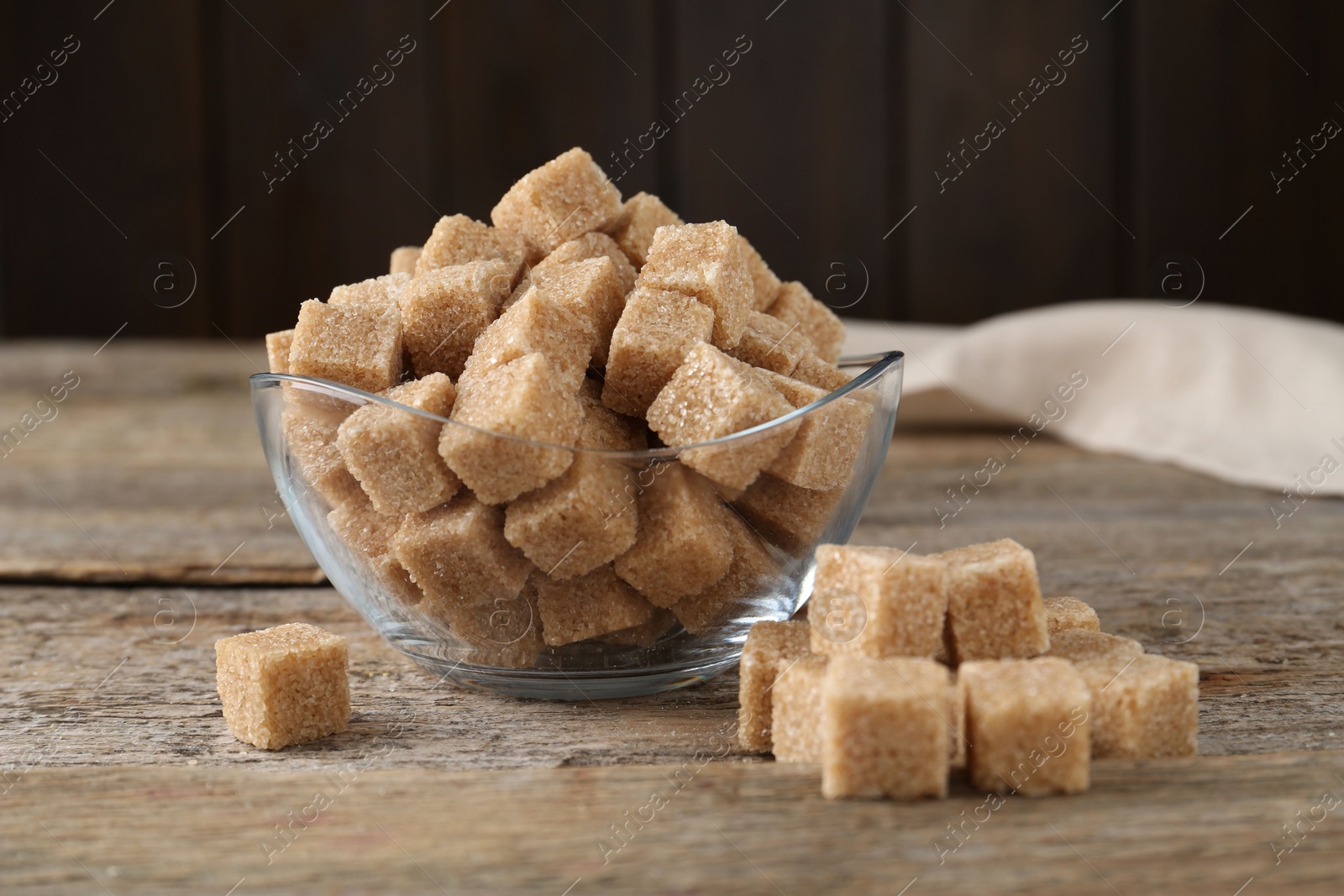 Photo of Brown sugar cubes on wooden table, closeup