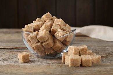 Photo of Brown sugar cubes on wooden table, closeup