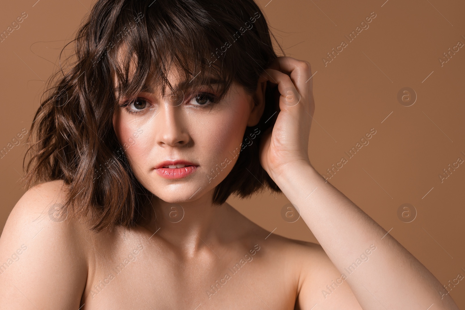 Photo of Portrait of beautiful young woman with wavy hairstyle on brown background. Space for text