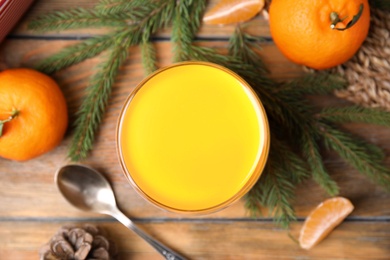 Photo of Delicious tangerine jelly and fir branches on wooden table, flat lay