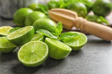 Ripe limes and mint on grey background. Refreshing beverage recipe