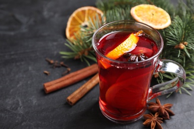 Photo of Tasty aromatic mulled wine on black table