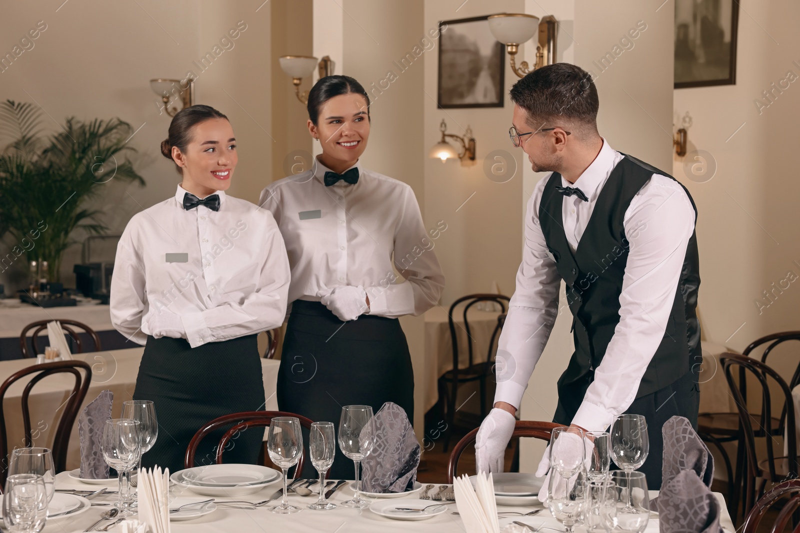 Photo of People setting table during professional butler courses in restaurant