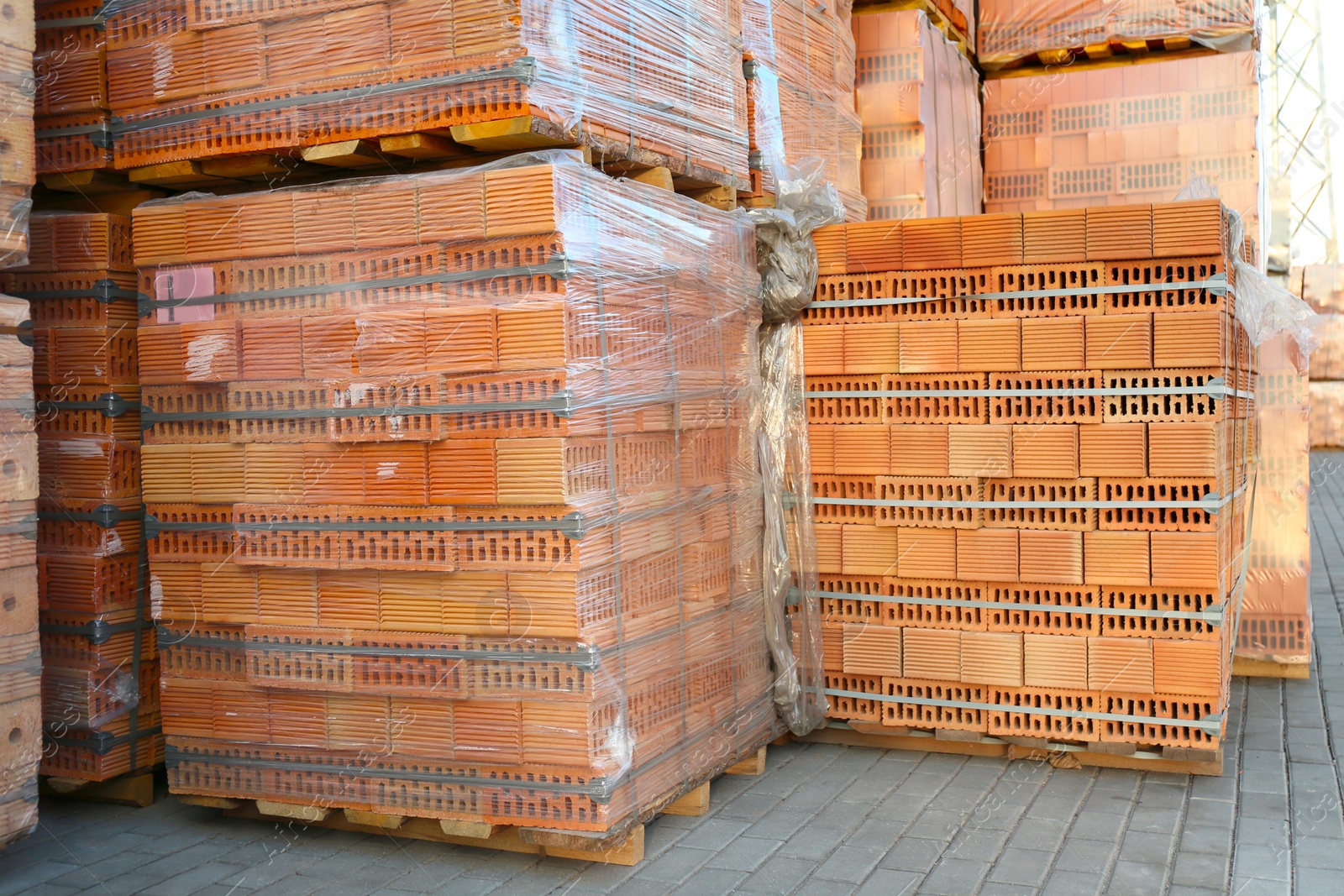 Photo of Pallets with red bricks outdoors. Building materials wholesale