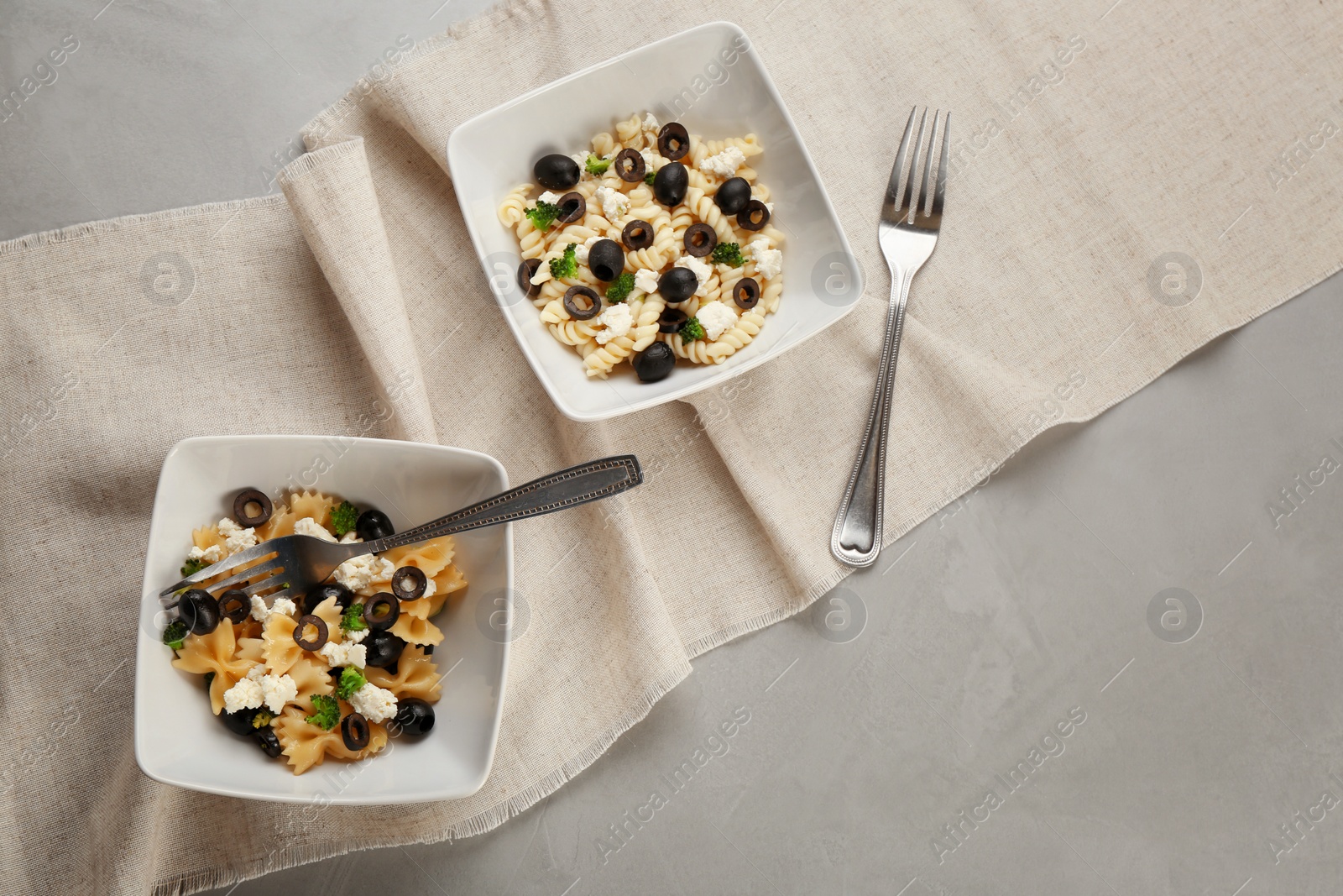 Photo of Tasty pasta salad with black olives on table