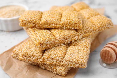 Delicious sweet kozinaki bars and wooden dipper on white table, closeup